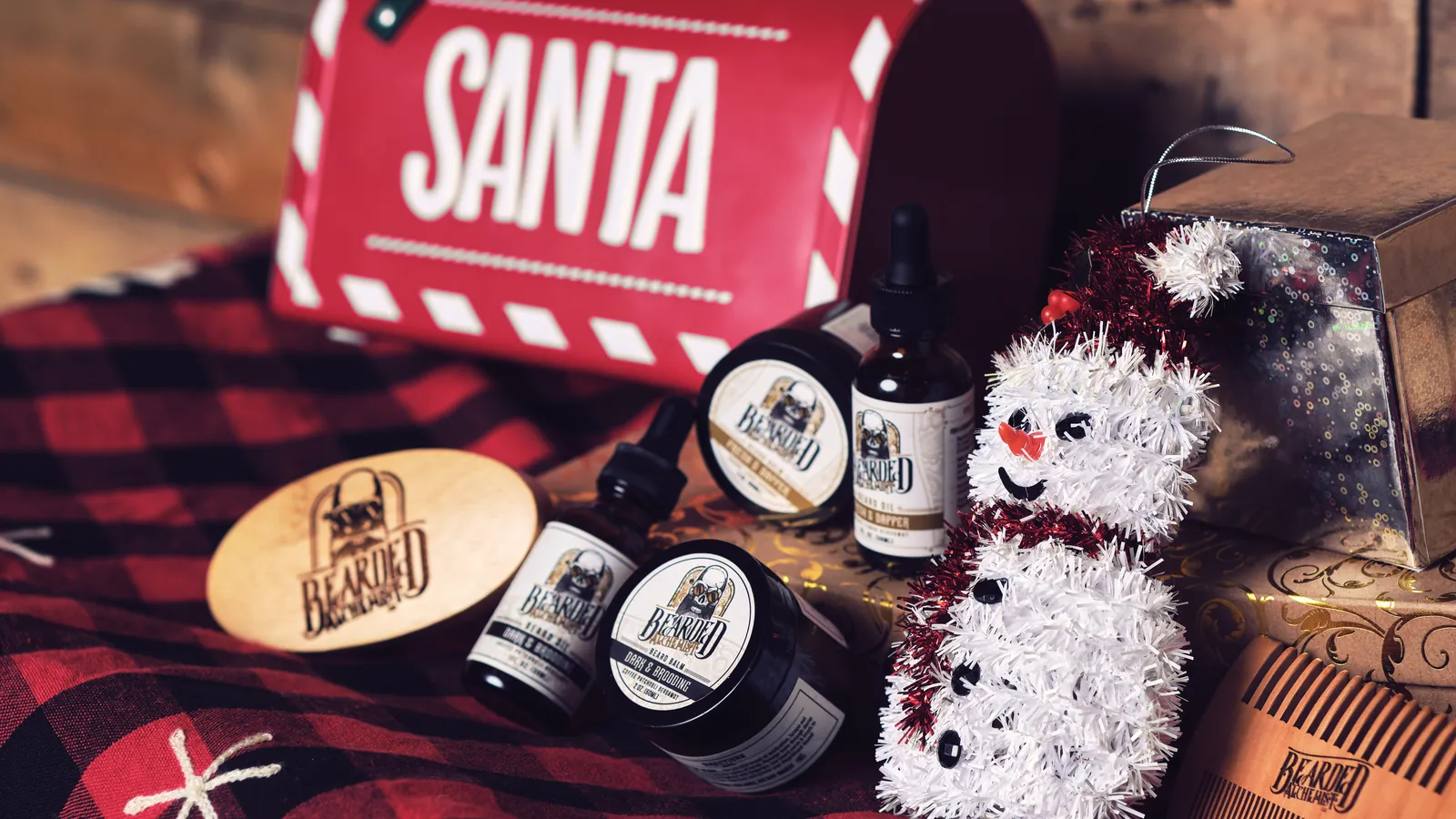 Festive beard care gift set with balm tins and oil bottles beside a Santa gift box