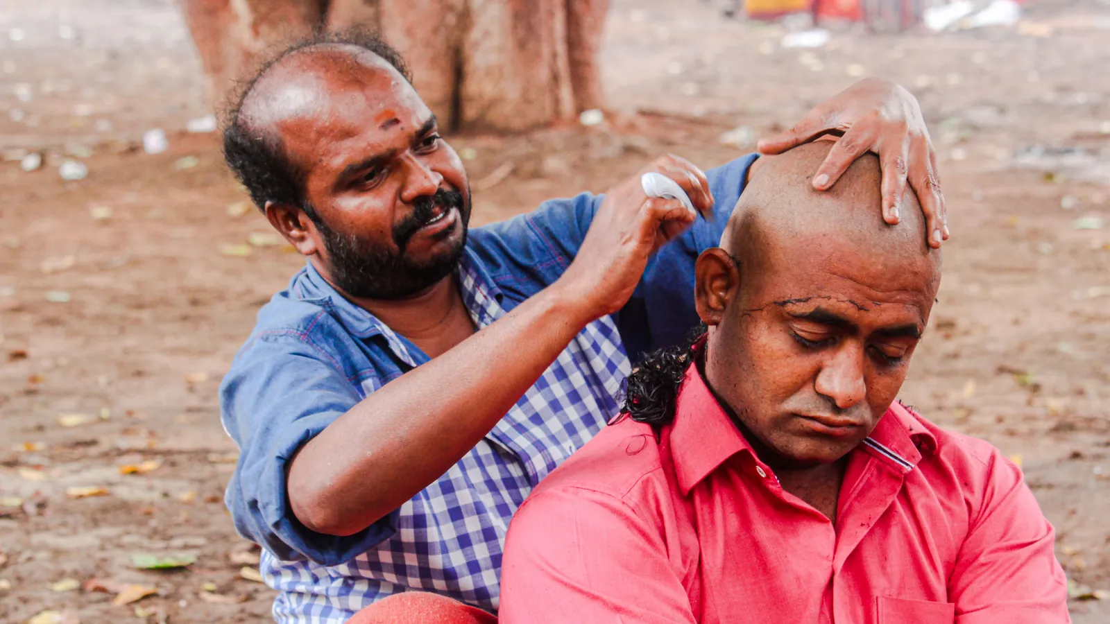 Barber shaving a man's head smooth with a razor