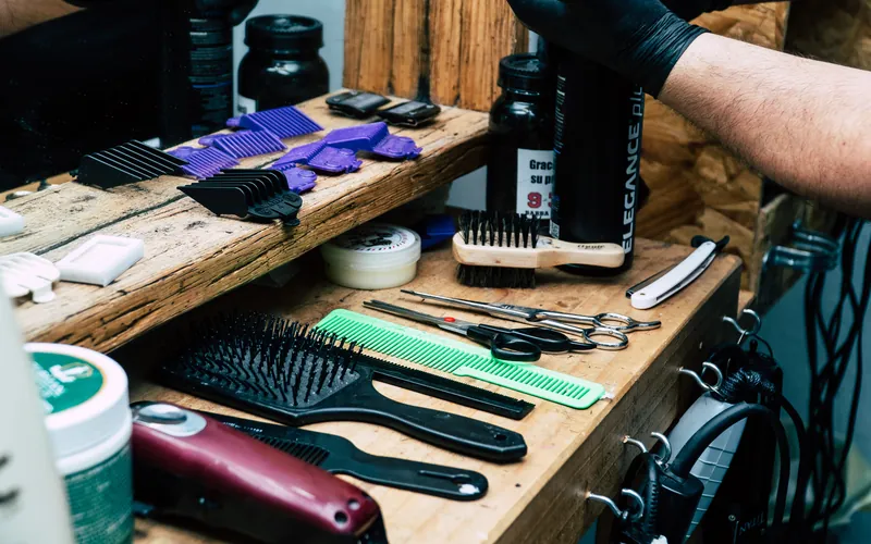 Scissors, combs and other barber tools laid out on a wooden counter