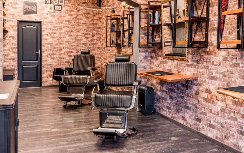 Barbershop interior with black leather chairs and brick walls